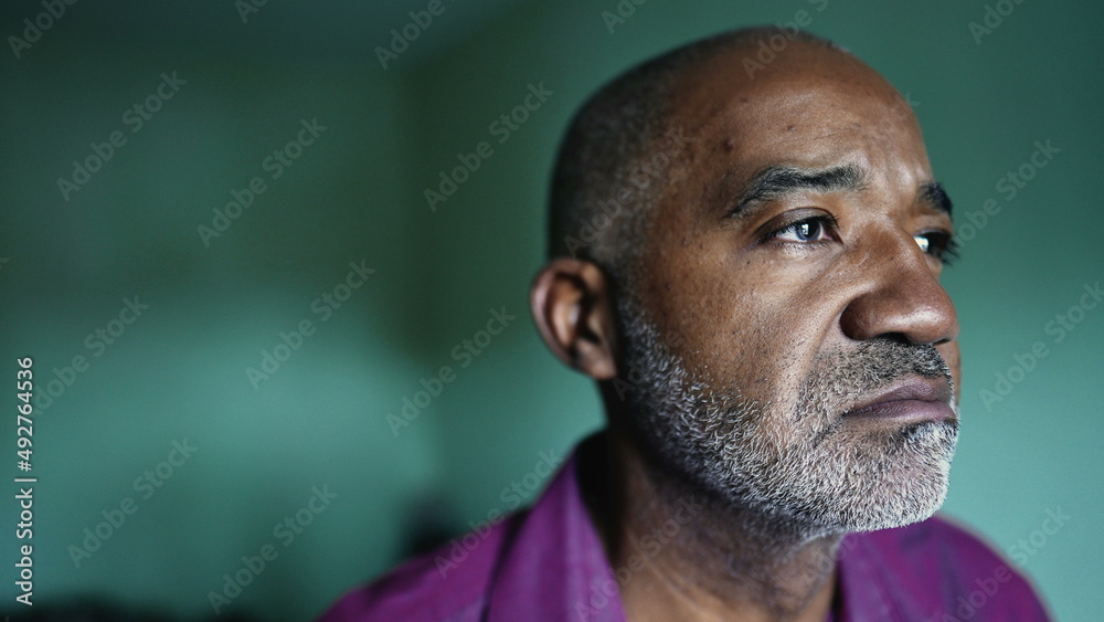 A thoughtful African man in bedroom thinking about life during middle life 50s A thoughtful African man in bedroom thinking about life during middle life 50s