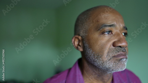 A pensive depressed black senior man thinking about life close-up face emotion