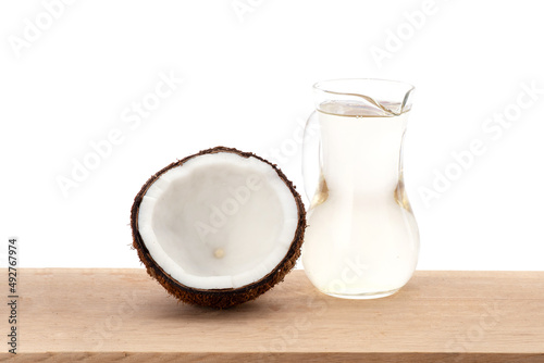 Coconut and oil on wood table and isolated on white background.