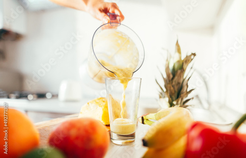 pouring fresh fruit smoothies into a glass. Peach, banana, apple. Close-up.Healthy food.