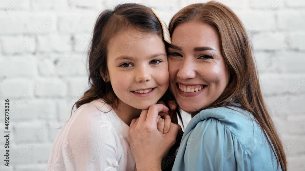 Happy cute affectionate adopted little kid girl hugging foster care parent mother with eyes closed, adorable small child daughter embrace mum cuddling enjoy tender sweet moment concept, close up view Happy cute affectionate adopted little kid girl hugging foster care parent mother with eyes closed, adorable small child daughter embrace mum cuddling enjoy tender sweet moment concept, close up view