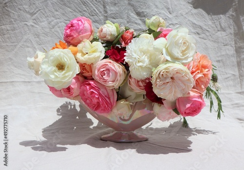 Vase of romantic vintage style roses on linen background