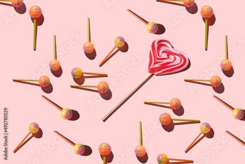 Colorful Set of Lollipops and chocolate. pattern made with caramel on a stick and chocolate on bright pink background. creative pattern. Sweet dessert.