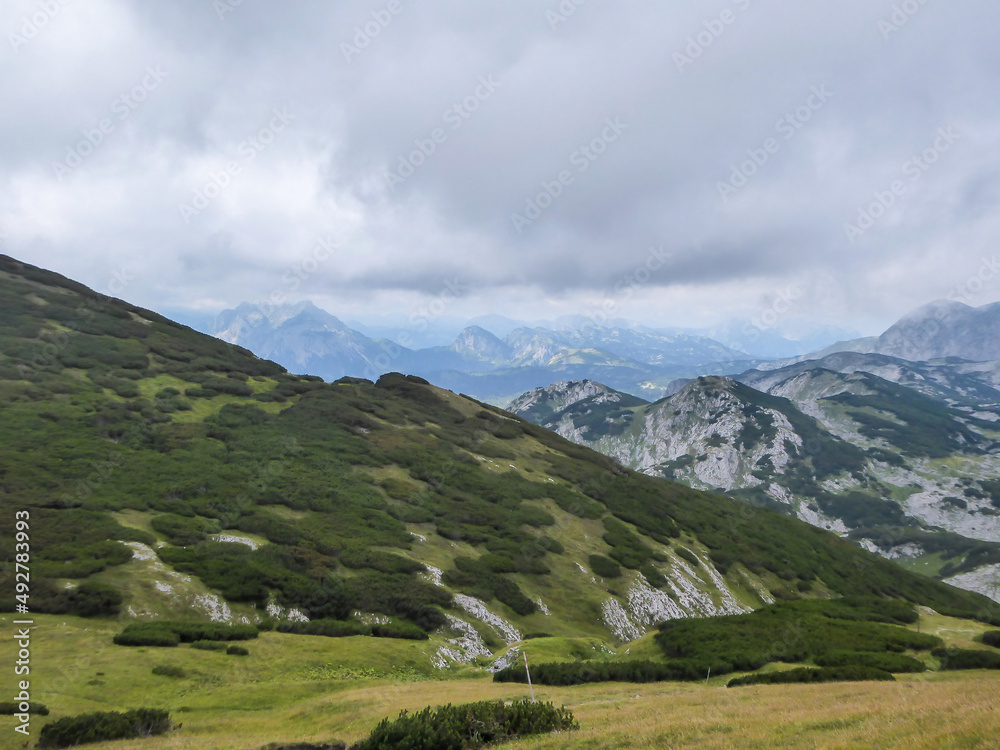 A panoramic view on the mountains in Hochschwab region in Austria. The vast plains spread along the mountain tops. Endless chains of the mountains. Overcast and cloudy day.