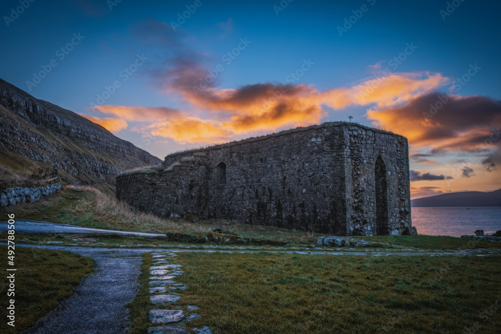 The ruins of St. Magnus Cathedral in Kirkjubour Kirkebo a historical village on Streymoy, Faroe Islands. The ruins are the largest medieval building in the Faroe Islands. Sunrise time, november 2021