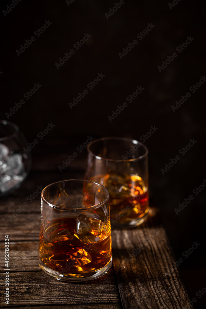 Two glasses of the whiskey with ice isolated on a dark background Two glasses of the whiskey with ice isolated on a dark background