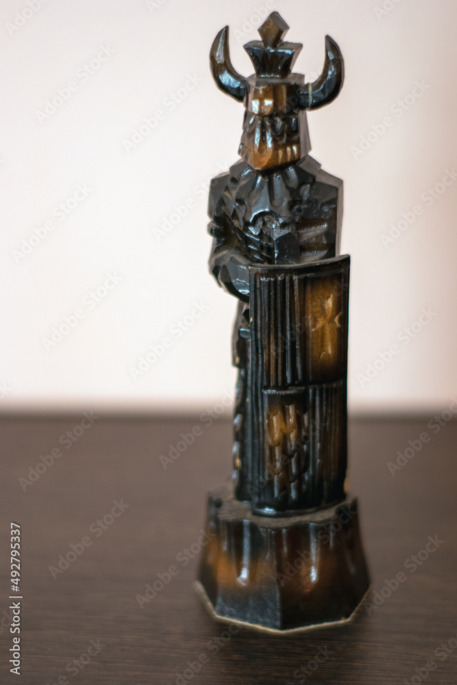 A Black figure stands on a table A Black figure stands on a table