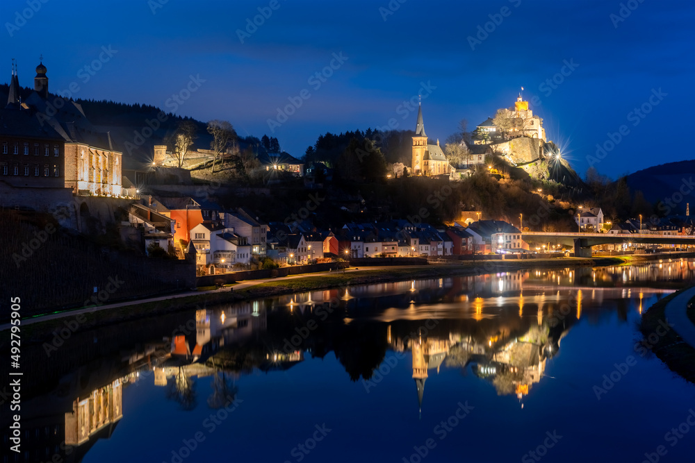 Saarburg panorama in Rhineland-Palatinate near Trier Germany and Luxemburg is a small touristic town with medieval centre. Blue hour twilight atmosphere with lights mirrored in River Saar.
