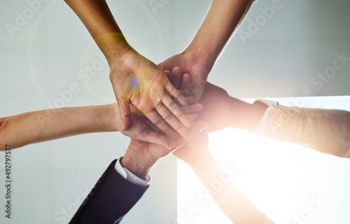 Share the goal, share the success. Low angle shot of a group of colleagues joining their hands in solidarity. © Delmaine D/peopleimages.com