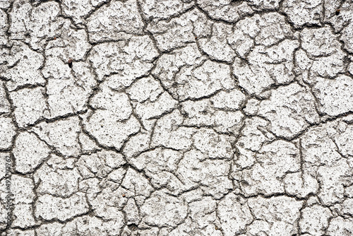 White paint asphalt cracks texture. Scratched lines background. White and black distressed grunge concrete wall pattern for graphic design. Dirty and destroyed surface. War destruction texture.