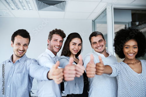 Youre doing an excellent job. Portrait of a group of businesspeople showing thumbs up in an office.