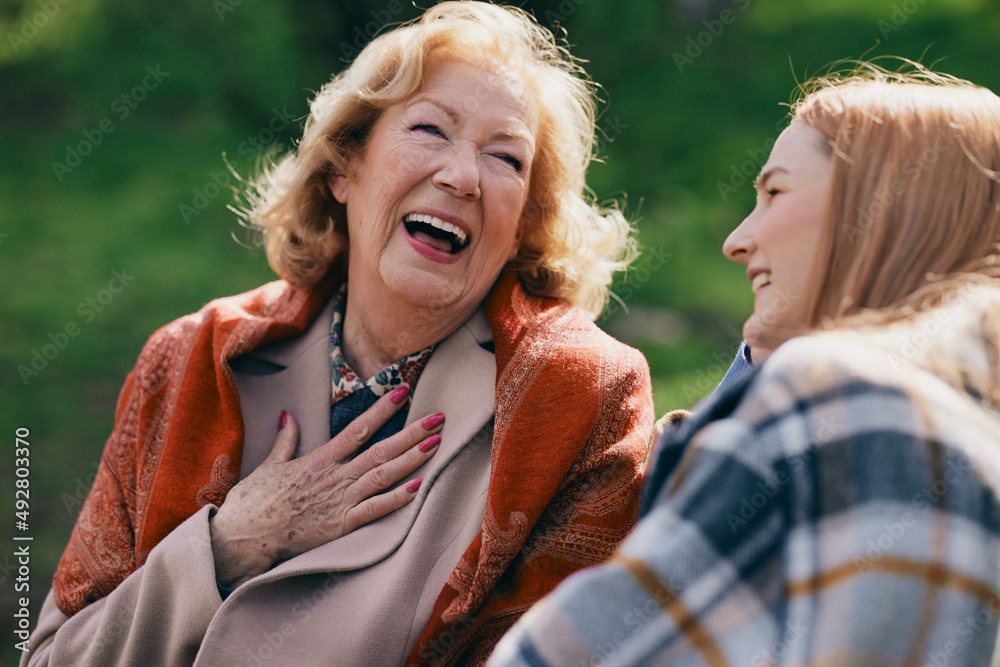 A happy senior woman laughing outside with granddaughter. A happy senior woman laughing outside with granddaughter.