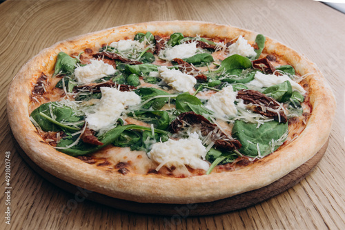 A baked Italian dish consisting of flattened bread dough covered variously with herbs, fresh vegetables, or, typically in the U.S., with tomato sauce, grated cheese, and, often, sausage, mushrooms, pe