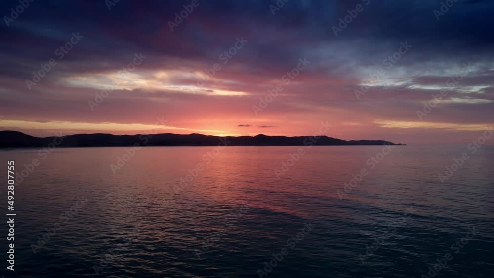 Mirror Reflection Of Sunset Sky In Serene Ocean Of Spirits Bay In Northland New Zealand. Aerial Pullback Mirror Reflection Of Sunset Sky In Serene Ocean Of Spirits Bay In Northland New Zealand. Aerial Pullback