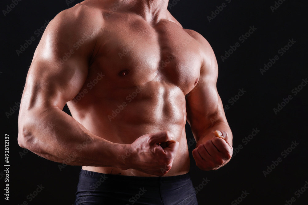 Professional bodybuilder posing over isolated black background. Studio shot of a fitness trainer flexing the muscles. Close up, copy space. Professional bodybuilder posing over isolated black background. Studio shot of a fitness trainer flexing the muscles. Close up, copy space.