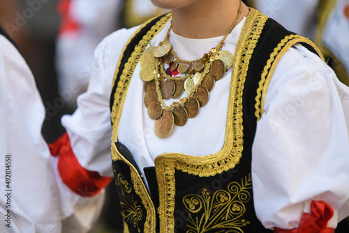 Closeup detail of beautiful necklace and waistcoat of traditional handmade folk costume from the Republic of Serbia on national festival parade. 15.09.2021 Belgrade, Serbia