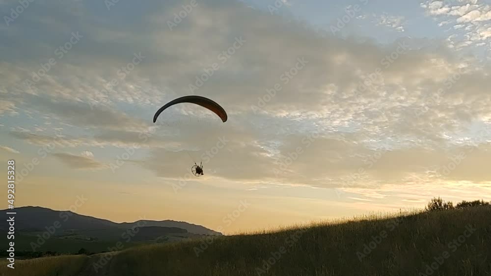 Paraglider flying on the parachute during sunset on the meadow. Slovakia Paraglider flying on the parachute during sunset on the meadow. Slovakia