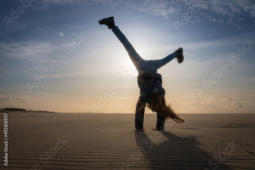 Girl doing a cartwheel on a beach photo