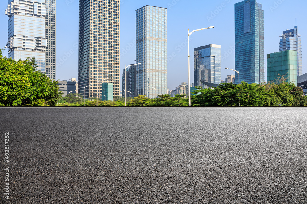 Asphalt road and city skyline with modern commercial buildings in Shenzhen, China.
