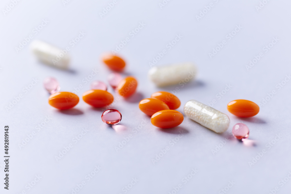 Vitamin E, Coenzyme Q10 and Vitamin C capsules. Antioxidants. Concept for a healthy dietary supplementation. Bright paper background. Soft focus. Close up. Copy space. Vitamin E, Coenzyme Q10 and Vitamin C capsules. Antioxidants. Concept for a healthy dietary supplementation. Bright paper background. Soft focus. Close up. Copy space.
