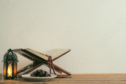 The Holy Al Quran with written Arabic calligraphy meaning of Al Quran and rosary beads or tasbih,