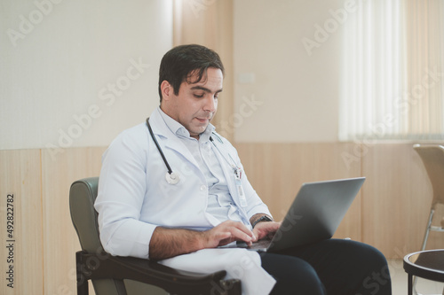 Doctor using laptop computer working in hospita photo