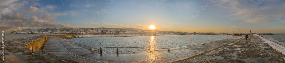 Panoramic view of Howth village and harbour with winter landscape at sunset, from the breakwater jetty, near Dublin, Ireland
