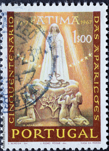 Portugal - circa 1967: a postage stamp from Portugal, showing the Marian Apparition of Fatima with Children Praying. 50th anniversary