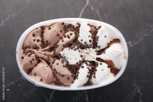 chocolate ice cream in a plastic container on black 