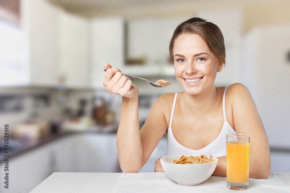 Young calm smiling happy housewife woman eat breakfast. Healthy diet lifestyle concept Young calm smiling happy housewife woman eat breakfast. Healthy diet lifestyle concept