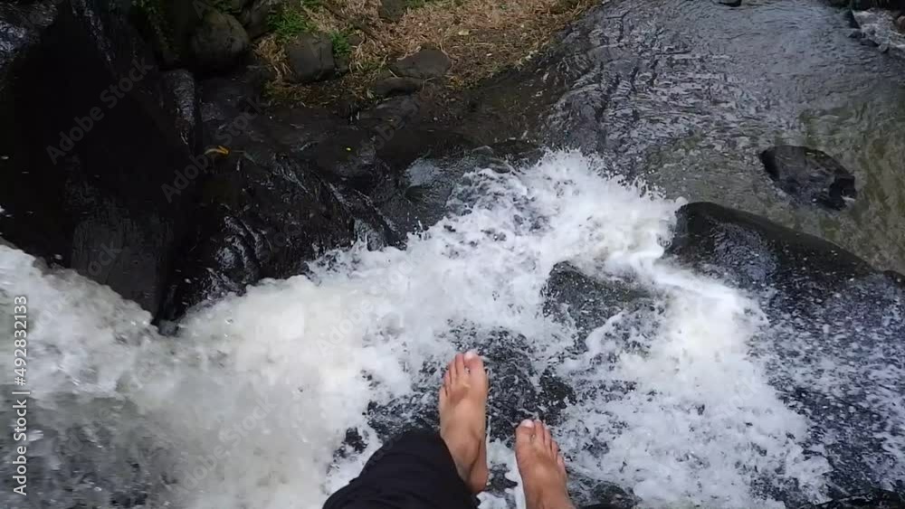 men's feet enjoying the fresh river water. travel in the mountains to enjoy the freshness of nature. sit and relax on the rocks with the fast flow of clean river water men's feet enjoying the fresh river water. travel in the mountains to enjoy the freshness of nature. sit and relax on the rocks with the fast flow of clean river water