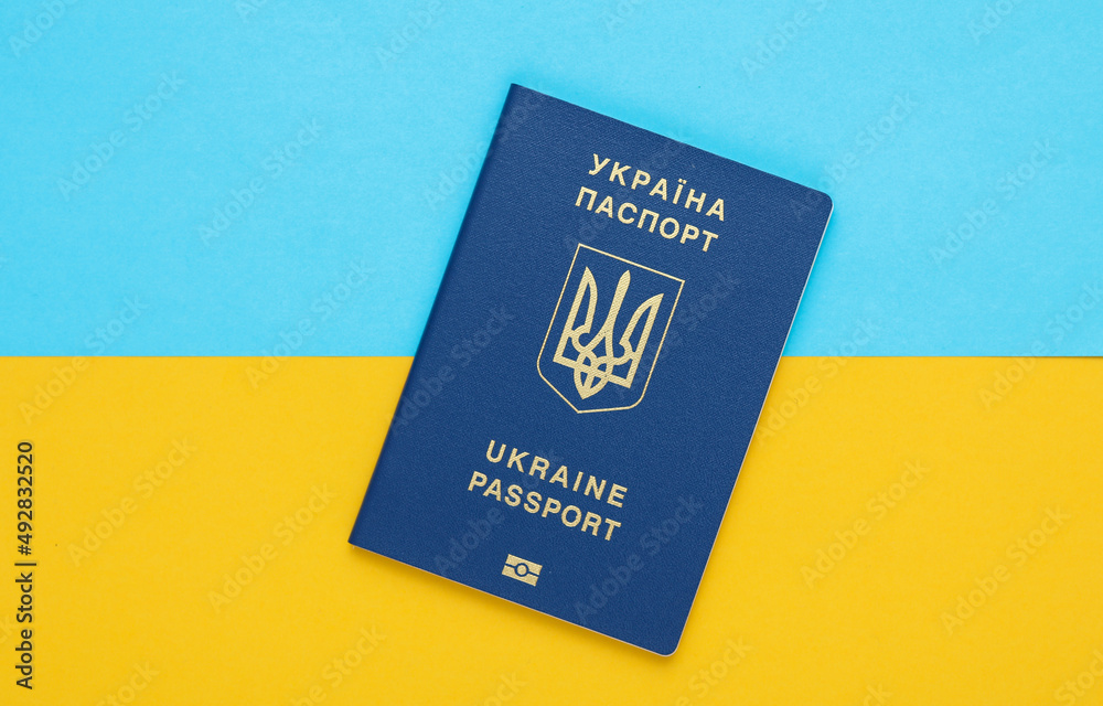 Ukrainian biometric passport on a yellow-blue background of the flag of Ukraine. Migration, Travel concept