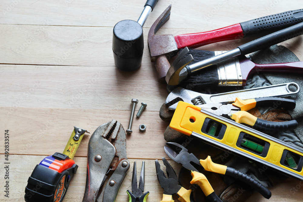 Hardware tools, equipment used for repair and maintenance work in general  technicians isolated on wooden background closeup. Photos | Adobe Stock