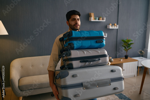 Young male tourist hurrying for vacation trip photo