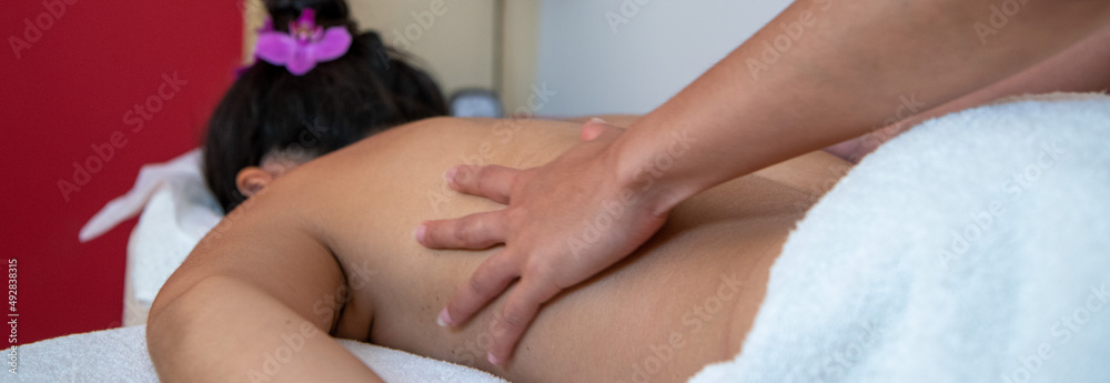 Junge Frau bekommt eine Wellness Thaimassage mit Aromaölen in einem Massagesalon Junge Frau bekommt eine Wellness Thaimassage mit Aromaölen in einem Massagesalon