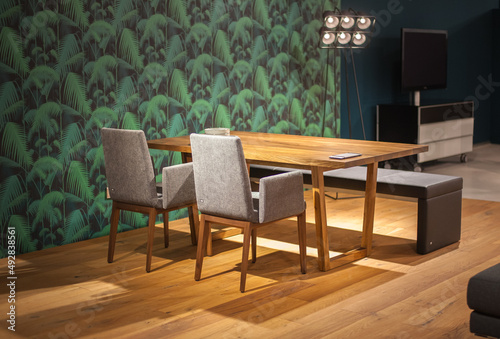 wooden dining table with modern chairs and a bench © Alevtina