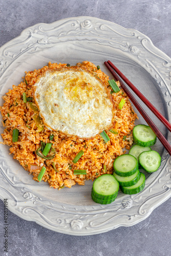  Nasi Goreng Indonesian Chicken Fried Rice with Fried Egg, Chili Sauce and Cucumber Top Down Photoc
 photo