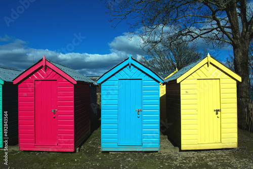 Iconic, old fashioned beach huts. Typical British seaside scene at Abersoch, north Wales on a sunny spring day. Close up view photo