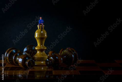 White chess King standing and fallen black chess pieces. Winner of business competition planning concept and marketing strategy. Macro