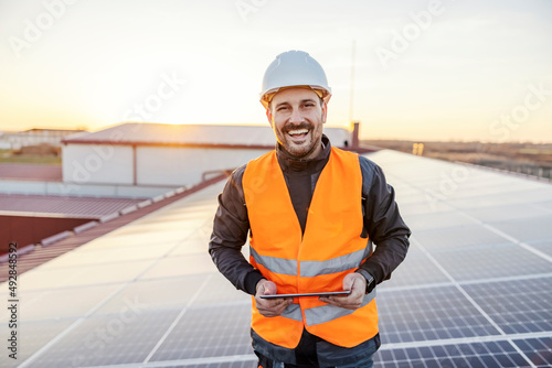 A happy worker testing solar panels with tablet. photo