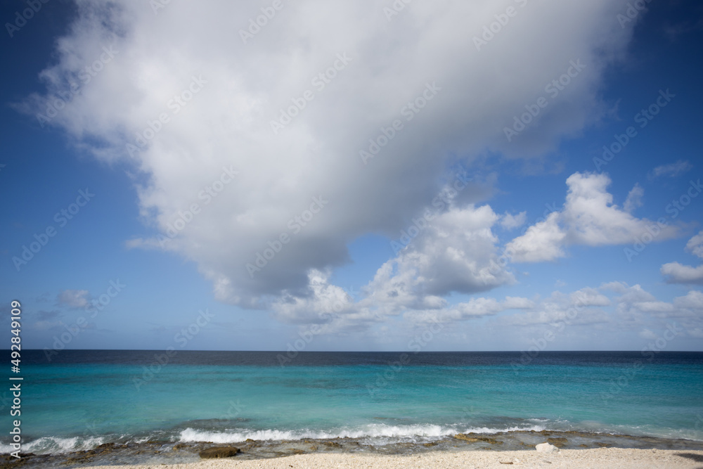 Turquoise sea, blue sky with big cloud. Seascape.