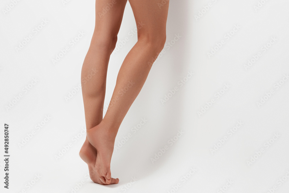 Slender beautiful female legs on white background.