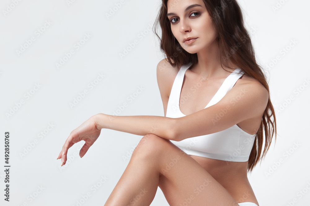 Beautiful girl in white lingerie on white background. Stock Photo