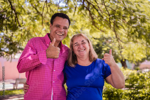 Older dating couple with thumbs up smiling