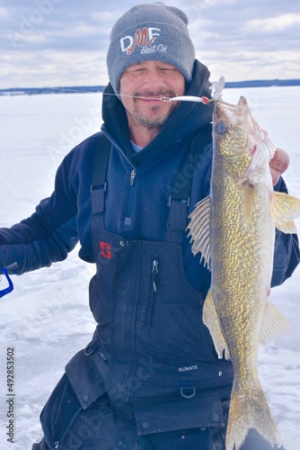 An ice angler with a walleye 
 photo