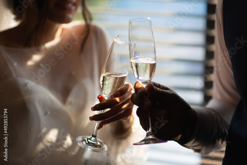 Obraz na płótnie Two glasses with sparkling champagne wine in hands of newlyweds in the wedding day. w salonie