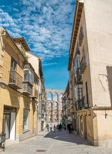 Calle en la ciudad de Segovia con el acueducto romano al fondo, España
