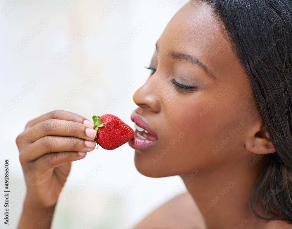The forbidden fruit. Shot of a beautiful young woman eating strawberries. The forbidden fruit. Shot of a beautiful young woman eating strawberries.