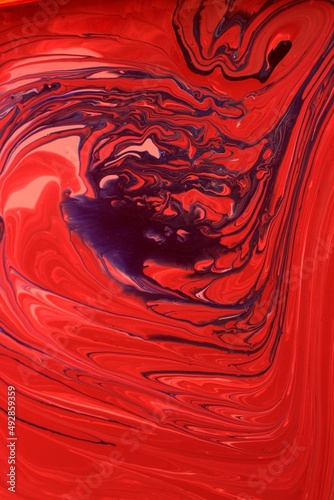 The background is made of black and red marble. Acrylic paint flows freely and creates an interesting pattern. Background for the cover of a laptop, laptop, book.