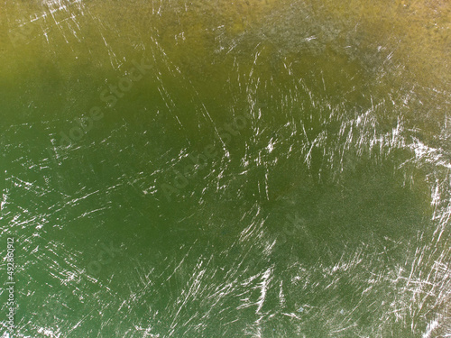 Green texture with white stripes. The texture of the ice lake.